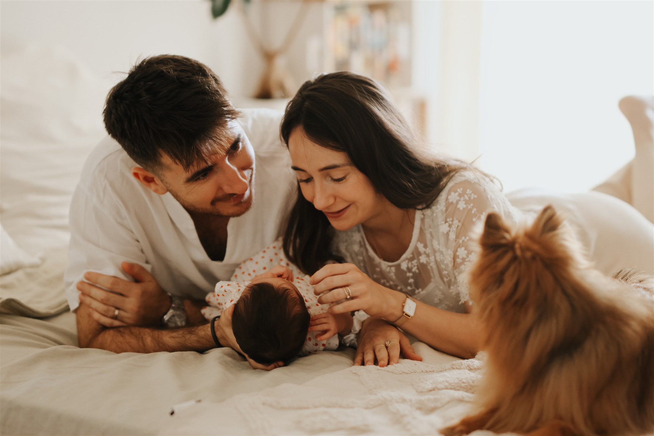 Parents, bébé et chien réunis sur un lit